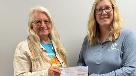 AAACU Team member presents a check to a member of the Cheboygan High School Senior Class of 2025